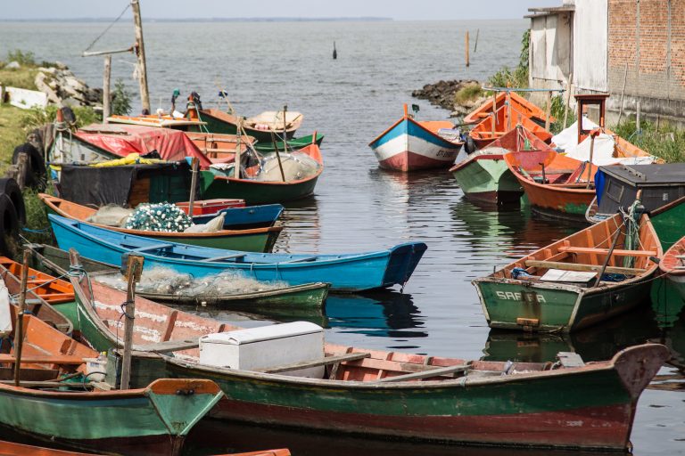 Pequenos barcos amarrados na beira do rio