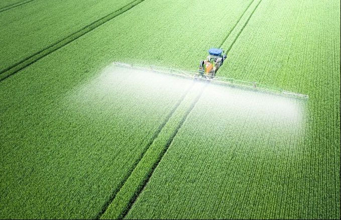 Aplicação de fertilizantes solúveis em água, pesticidas ou herbicidas no campo. Vista do drone. Defensivo agrícola.