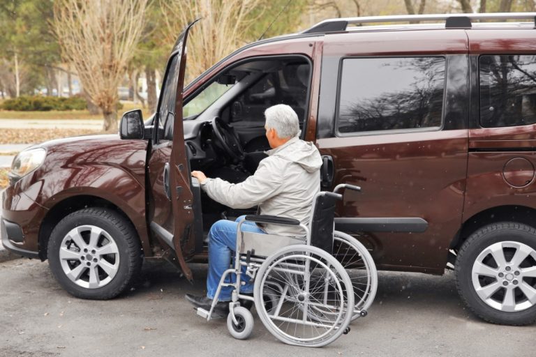 Pessoa em cadeira de roda entra num carro adaptado