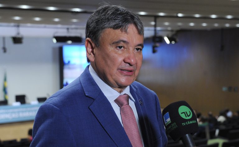 Um homem de terno fala ao microfone