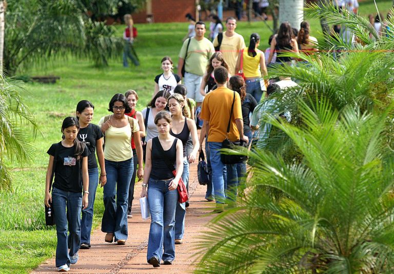 Estudantes caminham num campus durante o dia