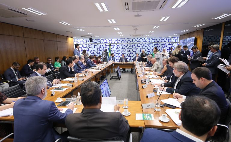 Homens sentados atrás de uma mesa