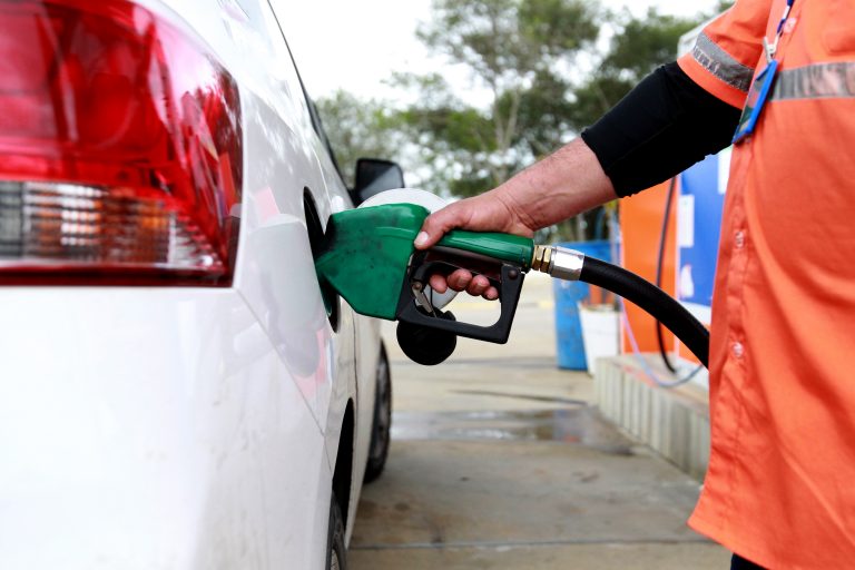Frentista de gasolina abastece um carro