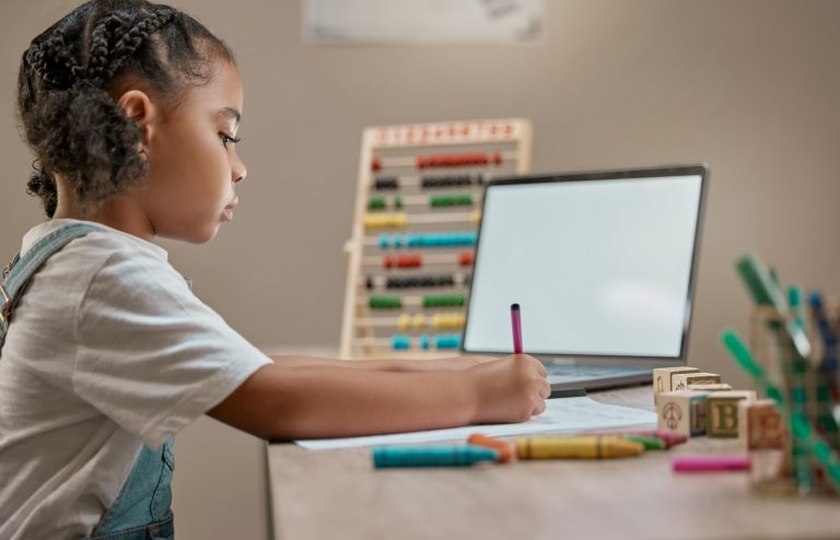 Criança usa computador para estudar