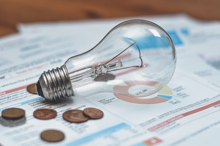 Lâmpada e moedas em cima de contas de luz