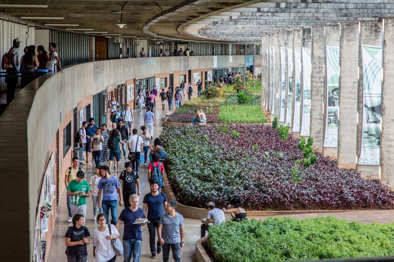 Campus universitário com alunos anadando nos corredores