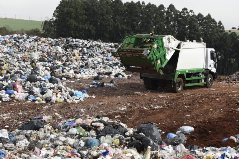 Caminhão descarrega resíduos coletados em lixão