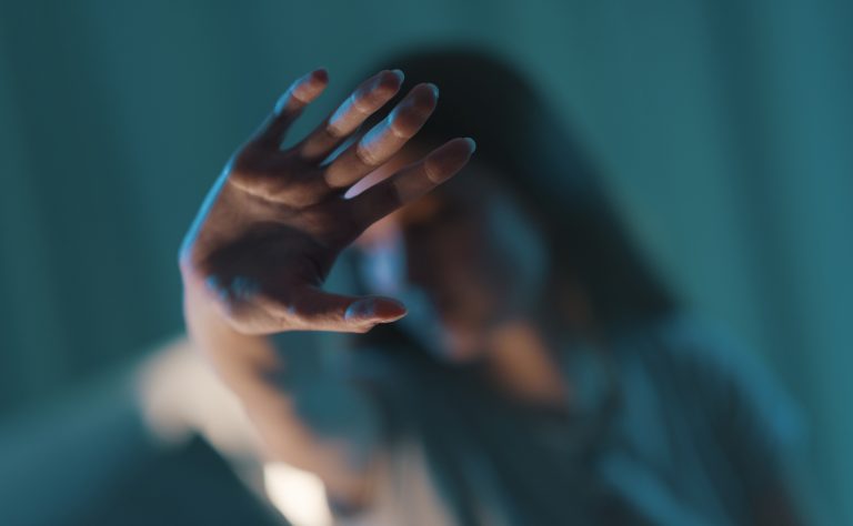mulher se protege com a mão