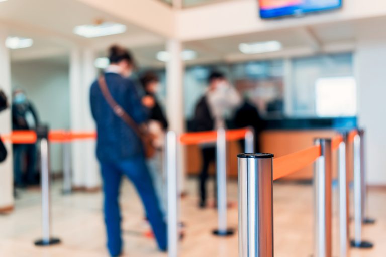 Pessoas na fila esperando atendimento no guichê