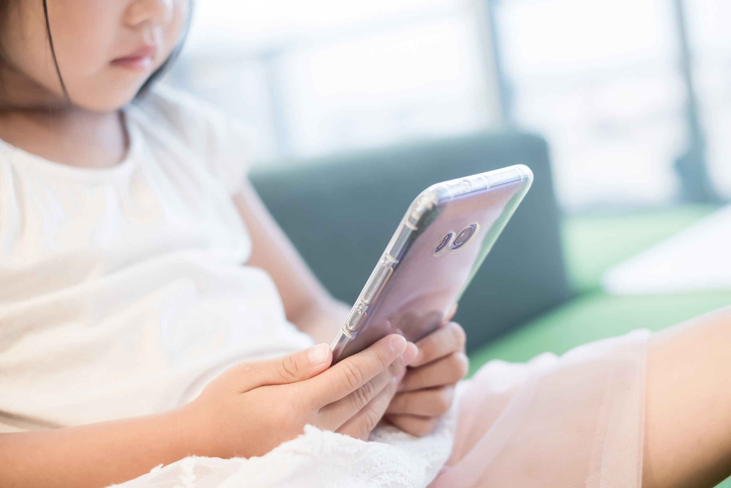 Tecnologia - geral - internet - rede social - crianças - crianças usam equipamentos eletrônicos (celular e tablet) - segurança virtual Criança com celular na mão olhando algum conteúdo