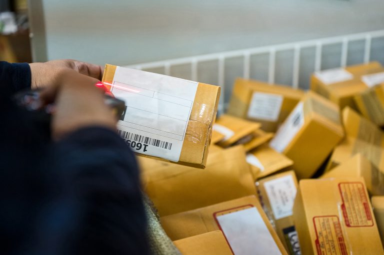Entregador lê código de barras de mercadorias para entrega