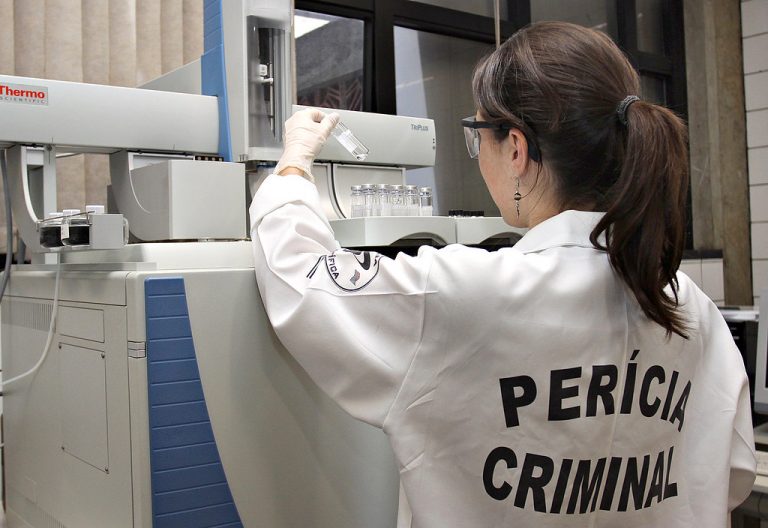 Perita criminal analisa prova em laboratório
