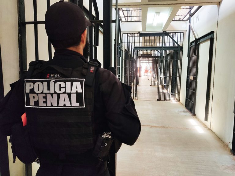 Um polícia protege a entrada de uma ala num presídio